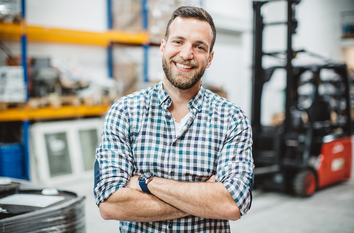 man smiling in a warehouse environment