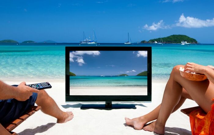 couple watching tv on the beach