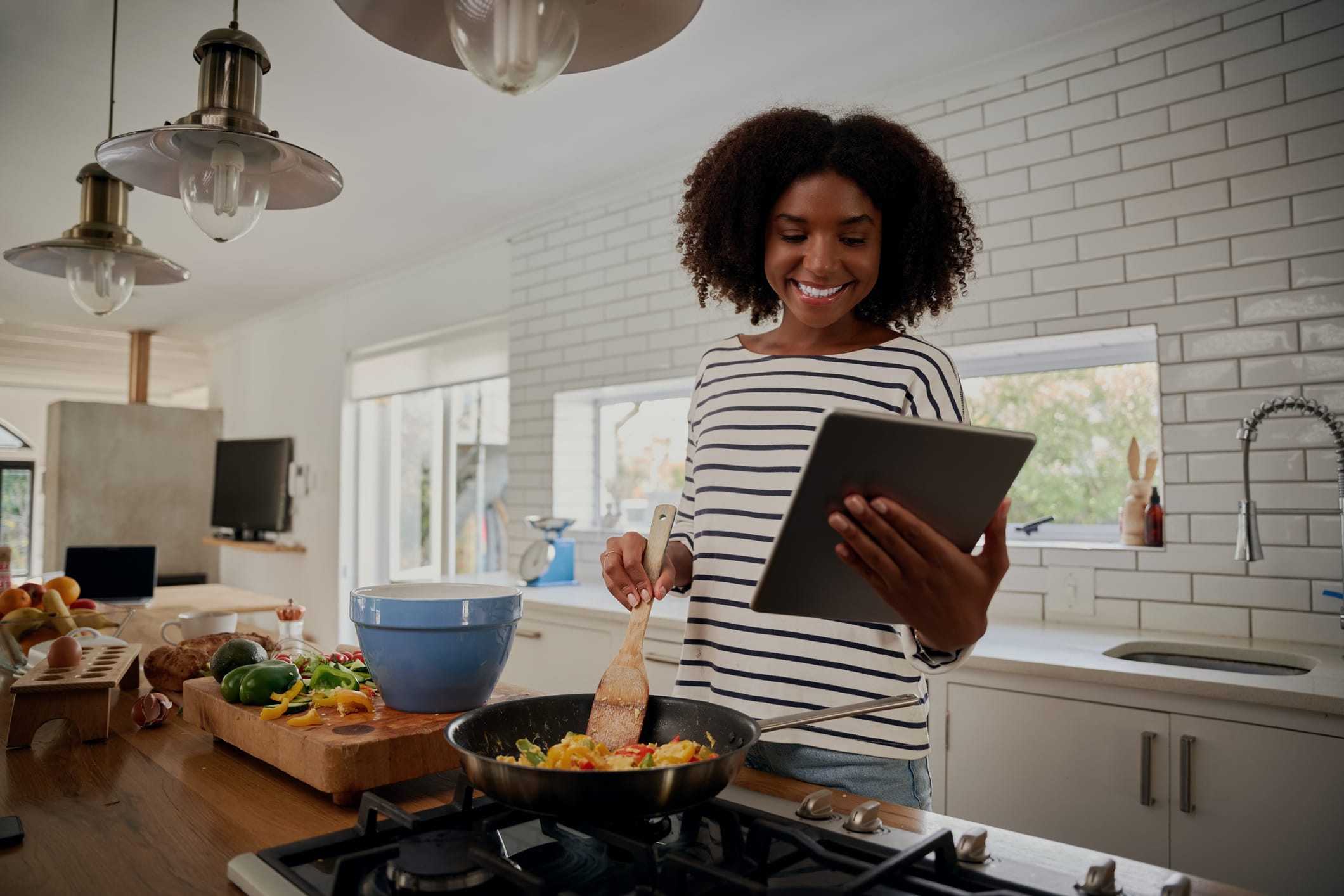 woman looking at tablet while cooking in the kitchen