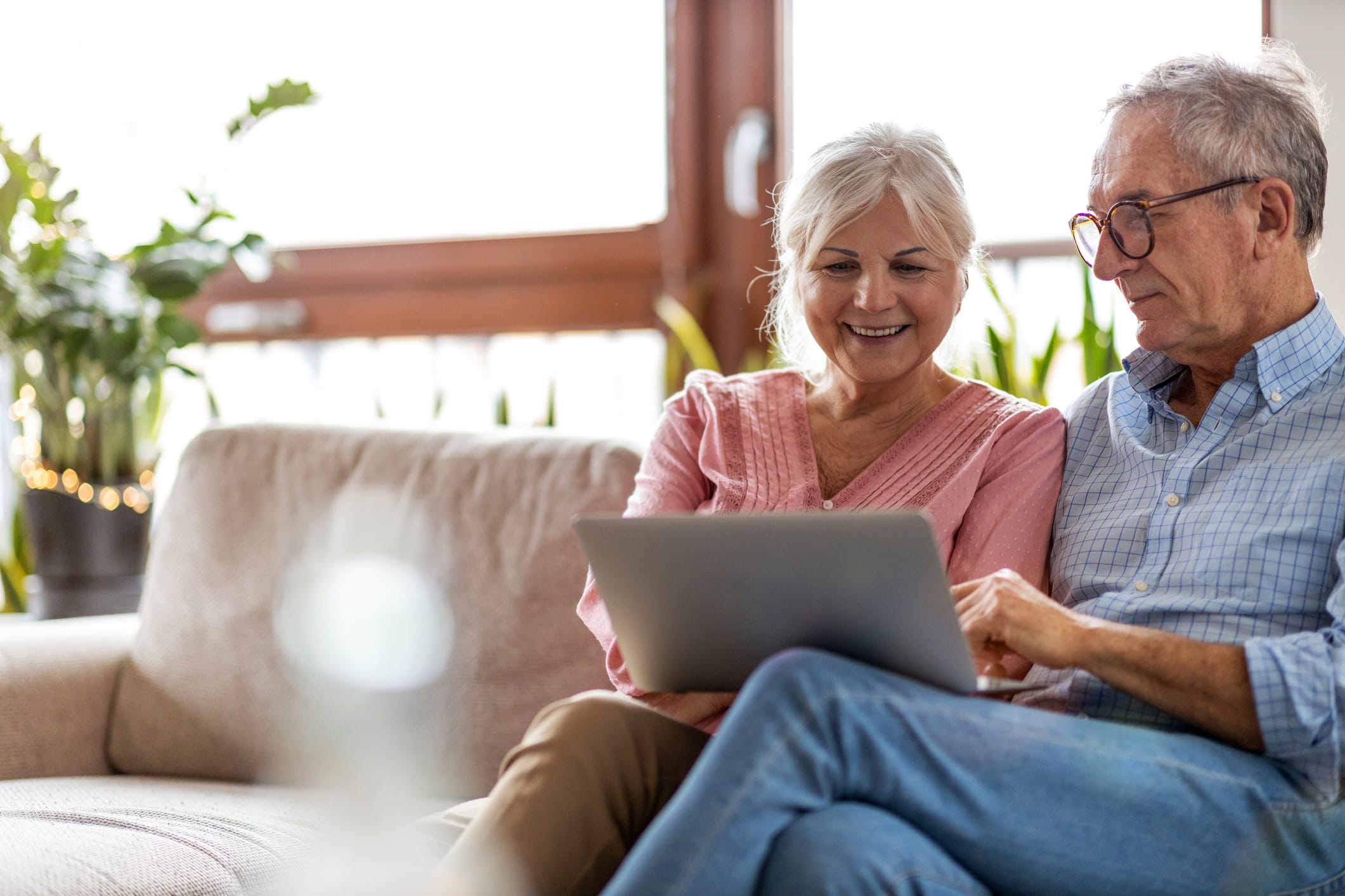 older couple looking at laptop on the couch
