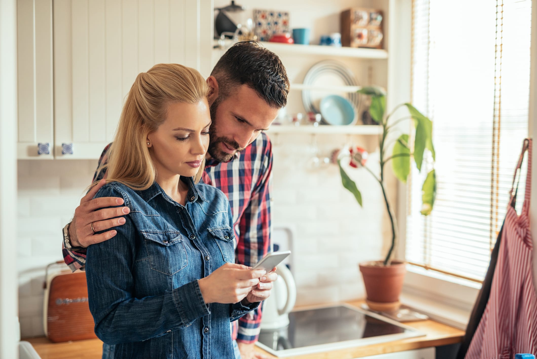 couple searching on phone in their kitchen