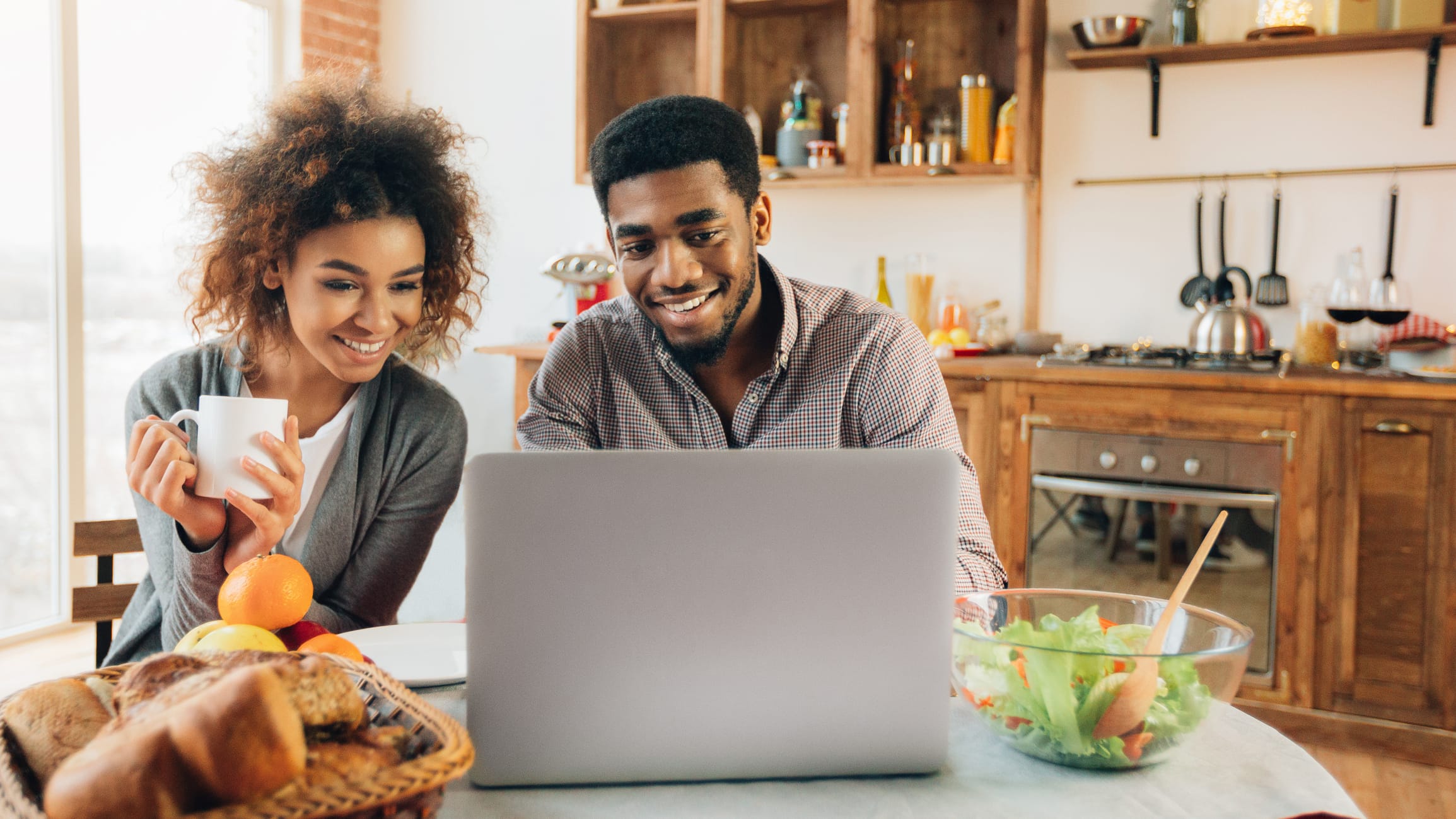 couple looking at laptop in their kitchen